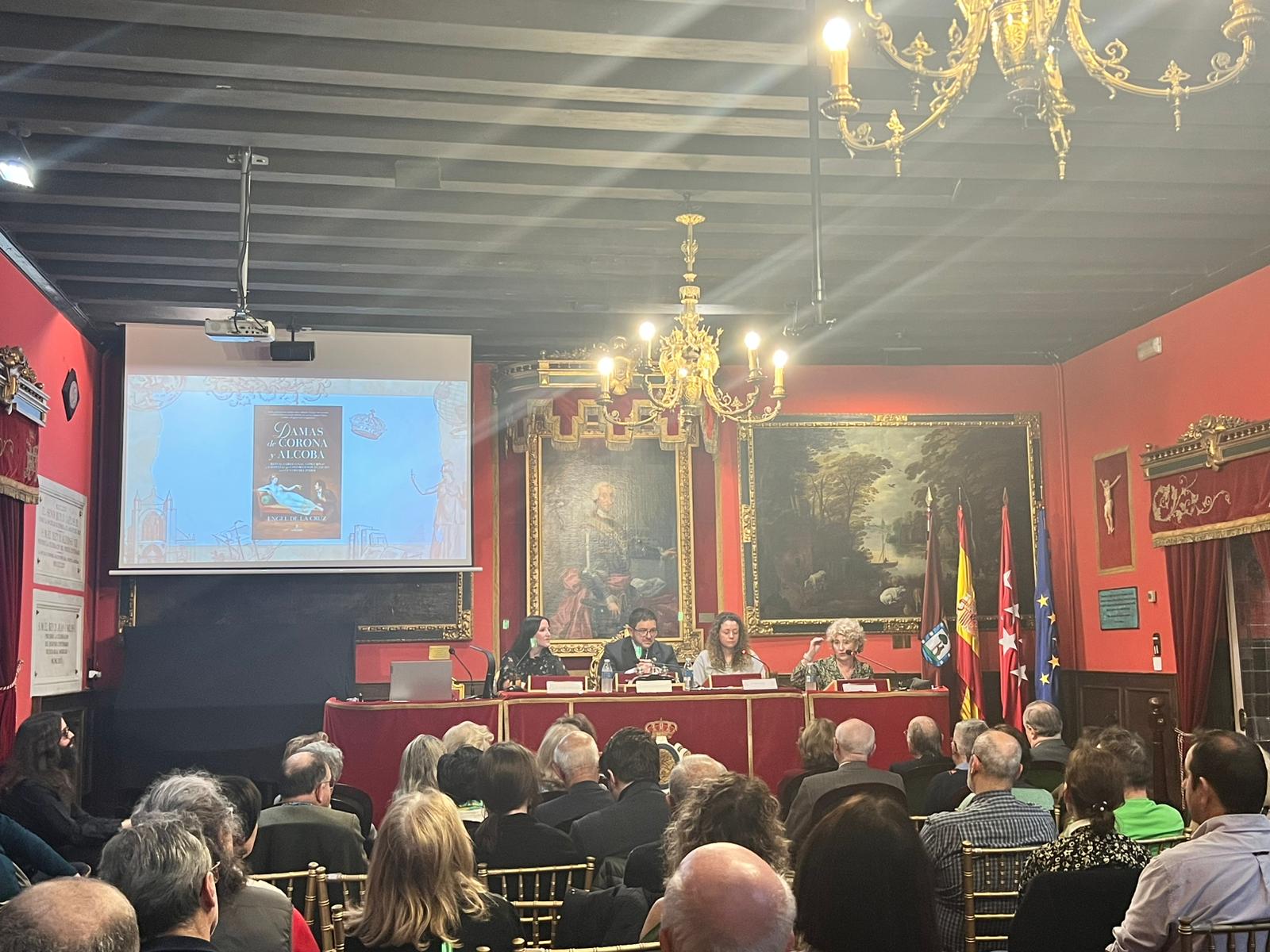 Fotografía horizontal general del salón durante una presentación de libro con numeroso público asistente.