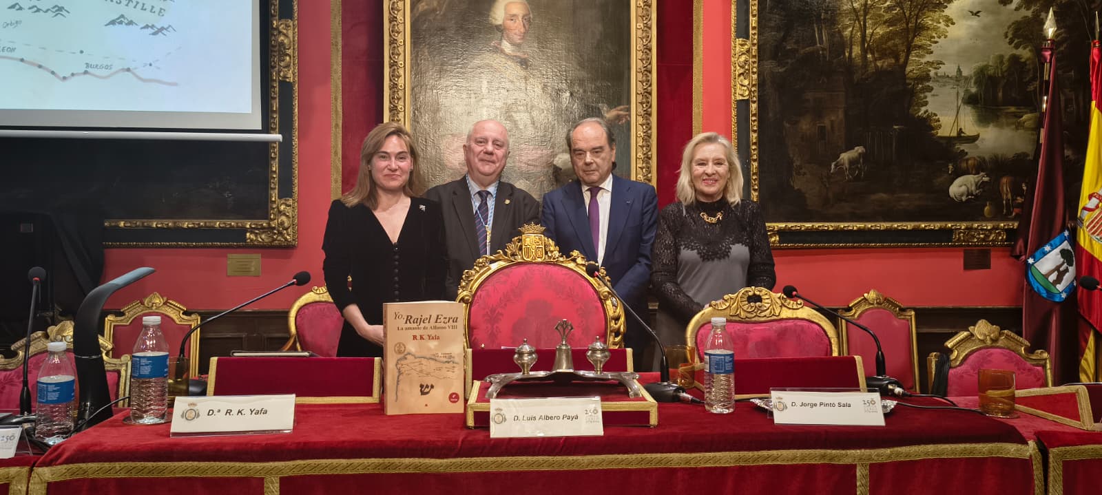 Fotografía horizontal de grupo junto a una mesa institucional con ejemplar del libro expuesto durante el acto.