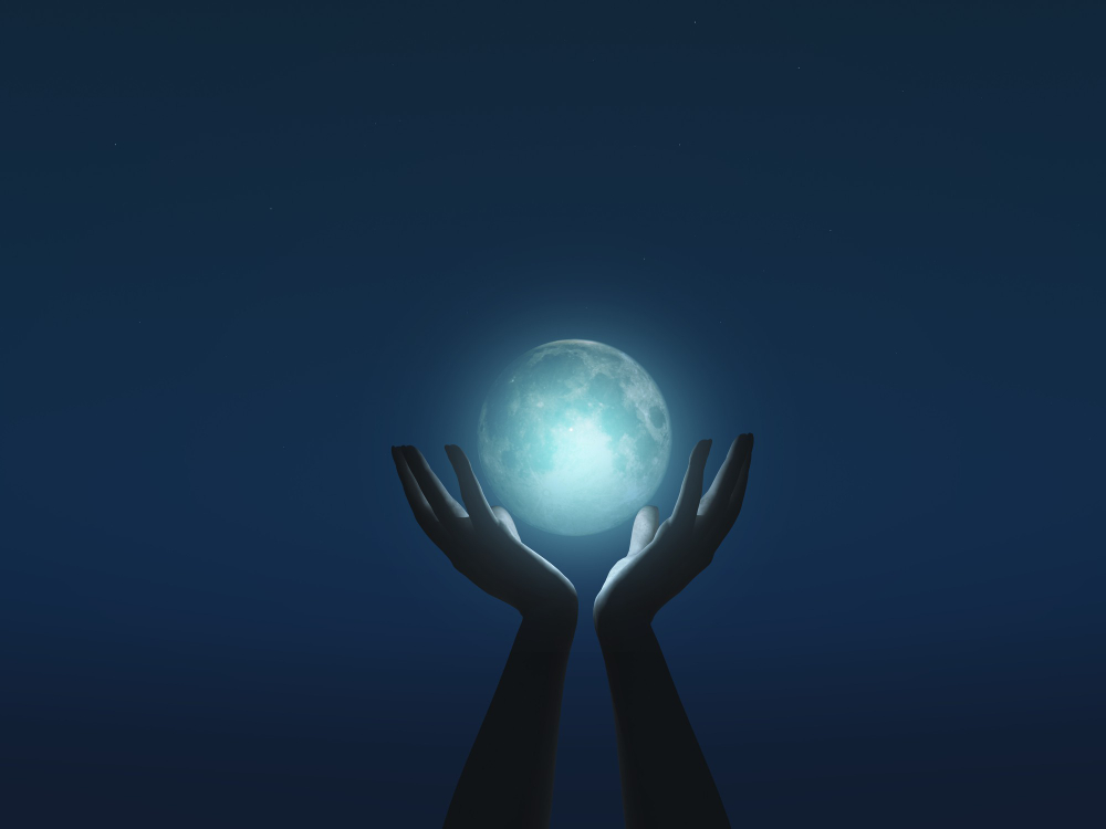 Manos sosteniendo una luna luminosa