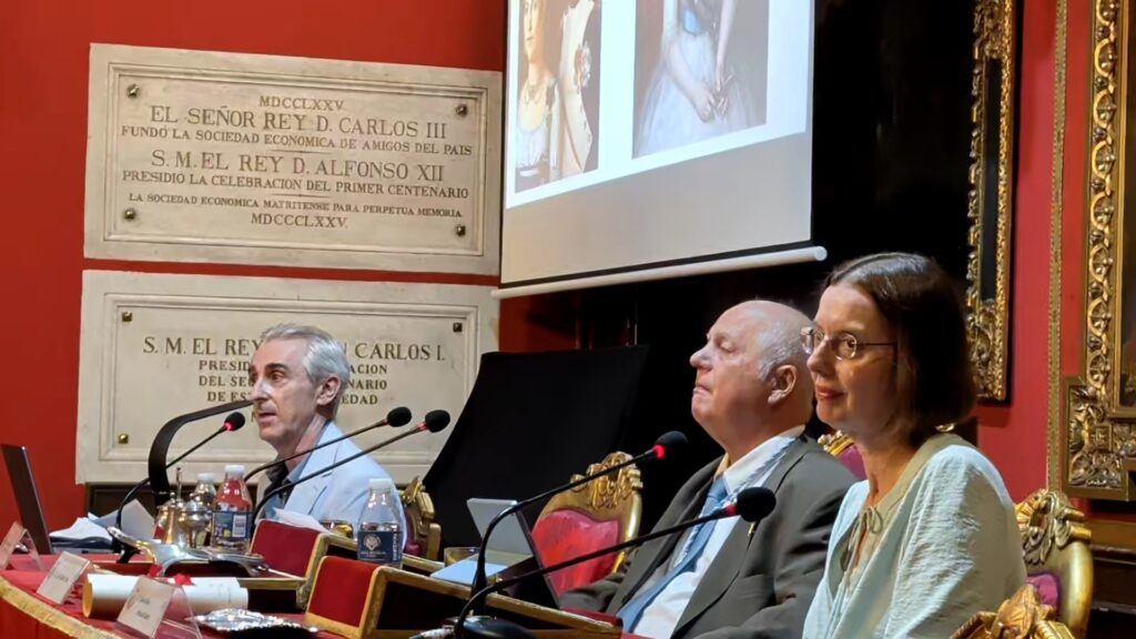 Tres participantes durante una intervencion en el acto Una infanta frente a Napoleon. Fotografia lateral de tres participantes sentados ante microfonos en la mesa del acto Una infa