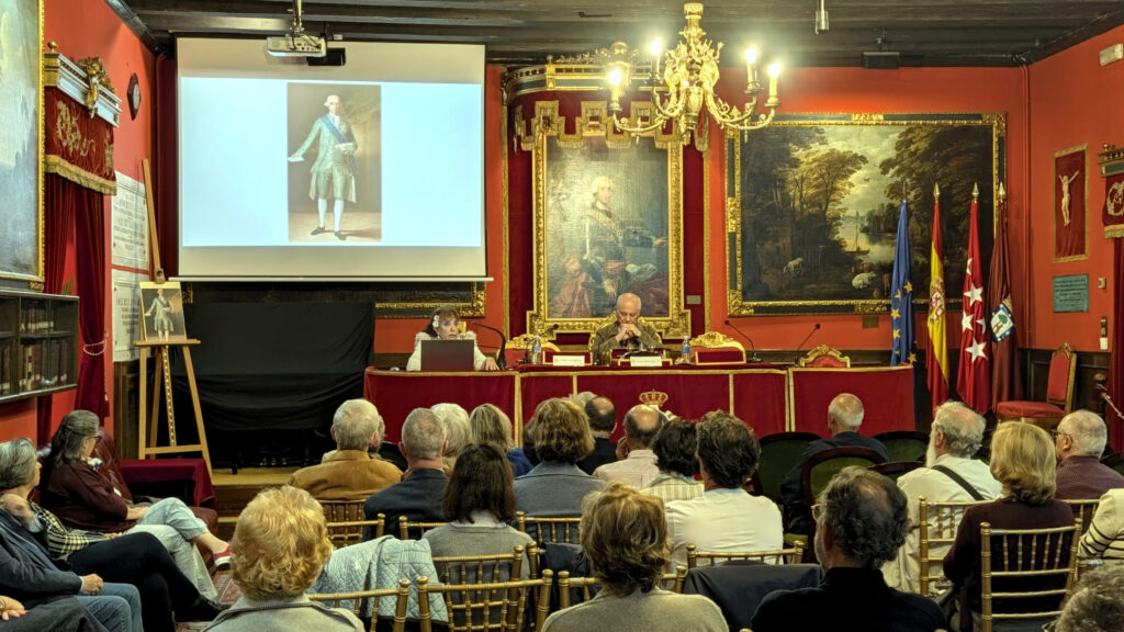 Fotograf?a documental tomada en el sal?n hist?rico de la Real Sociedad Econ?mica Matritense de Amigos del Pa?s, en Madrid. La imagen muestra una vista general de la conferencia: do