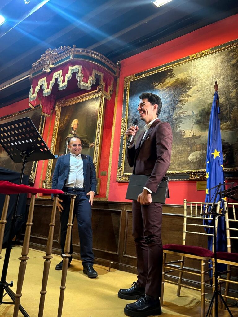 Fotograf?a vertical realizada en el sal?n hist?rico de la Real Sociedad Econ?mica Matritense de Amigos del Pa?s, en Madrid. La escena muestra a dos participantes sobre el escenario