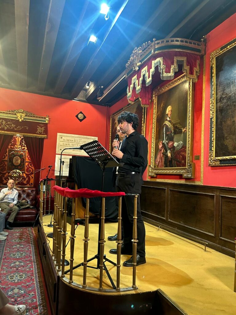 Fotograf?a vertical tomada en la Real Sociedad Econ?mica Matritense de Amigos del Pa?s, en Madrid. La imagen muestra a dos participantes en el escenario, junto a un atril y un micr