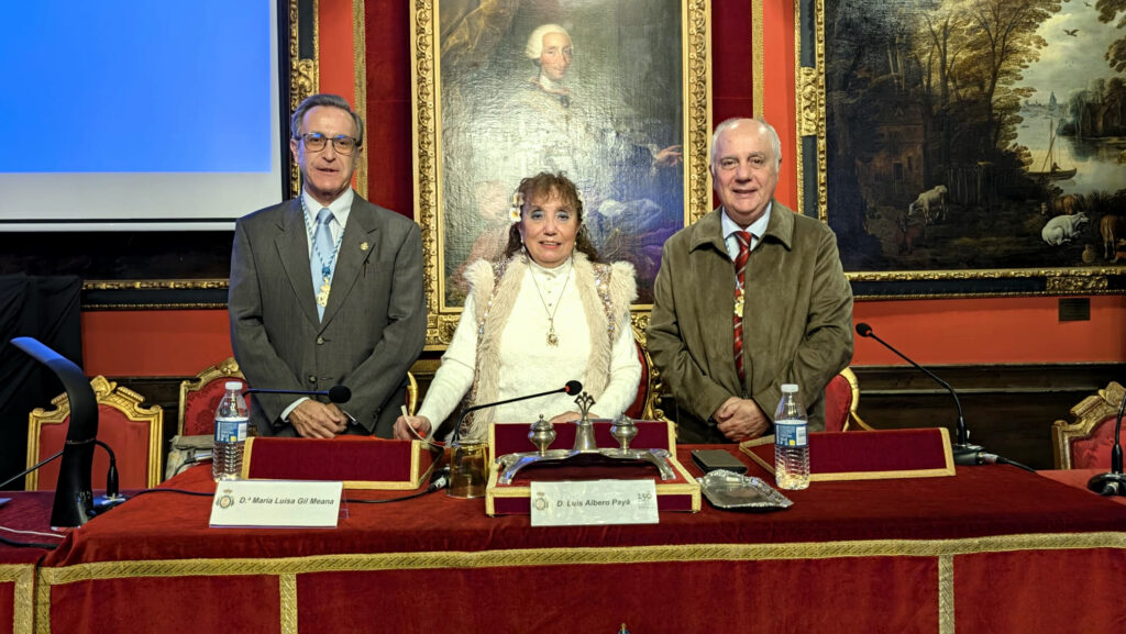 Fotograf?a de grupo realizada en el sal?n hist?rico de la Real Sociedad Econ?mica Matritense de Amigos del Pa?s, en Madrid. Tres participantes posan de pie tras la mesa principal d
