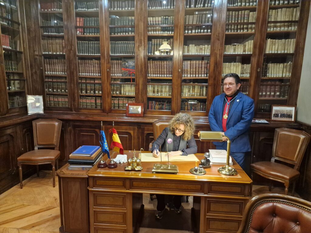 Firma en un libro institucional durante la visita a la biblioteca histórica de la Matritense, en el contexto de la presentación de Los ángeles insurrectos.